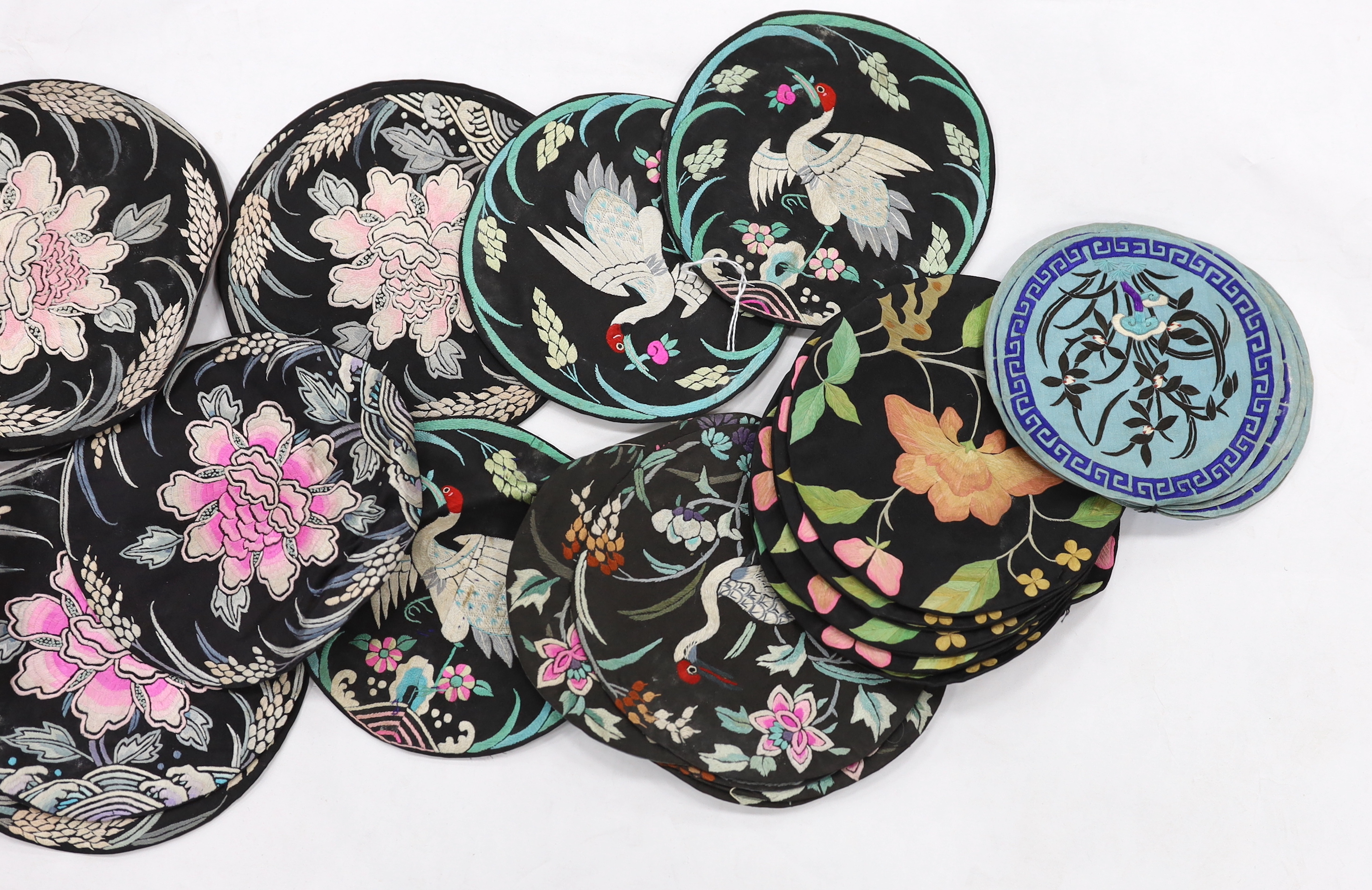 Four sets of eight circular Chinese silk embroidered mats and a set of three similar mats, all depicting birds and stylistic flowers
